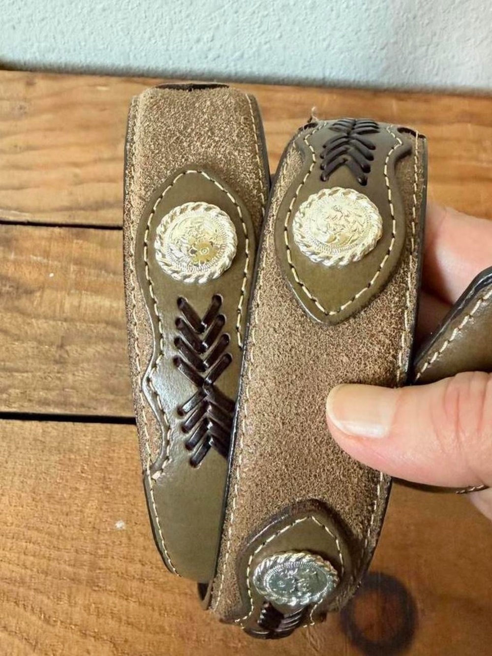 Western brown leather belt with silver conchos. Intricate design by Nocona